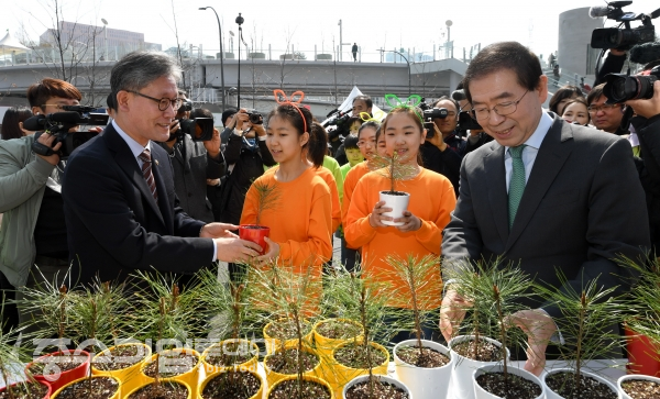 김재현 산림청장(왼쪽)과 박원순 서울시장 어린이들에게 나무를 나눠주고 있다. 사진 = 산림청 제공