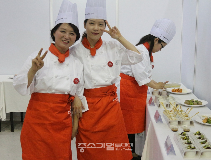 이번 대회에 참가한 엄마와 딸이 심사장에 요리를 제출하고 기념사진을 찍고 있다.