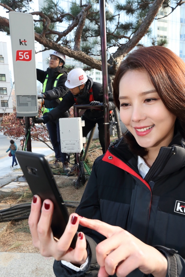 KT 직원들이 광화문에 설치된 5G 기지국을 점검하며, 삼성 5G 스마트폰 시제품을 테스트 하고 있다. [KT]