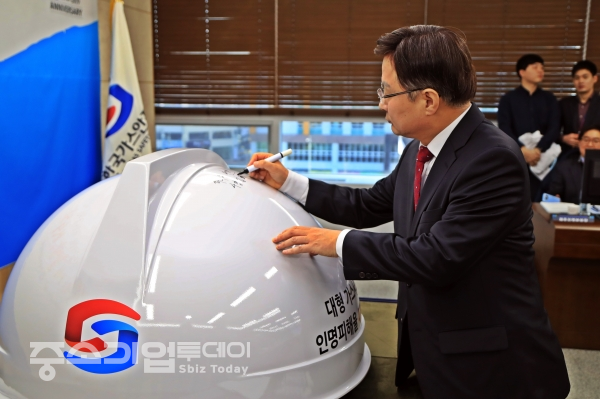 김형근 사장이 초대형 안전모에 안전 문구와 서명을 하는 퍼포먼스를 진행하고 있다.