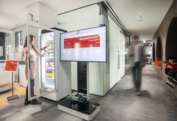 SKT 홍보 모델이 5G Cafeteria에서 무인 자판기를 활용해 음료를 고르고 있다. [SKT]