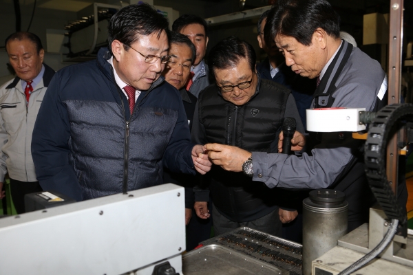 김기문 중소기업중앙회 회장(앞줄 왼쪽)이 박순황 건우정공 대표(앞줄 오른쪽)로부터 생산시설에 대한 이야기를 듣고 있다.