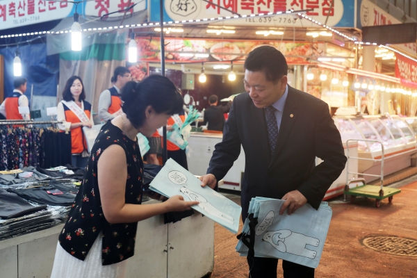 허영회 소상공인시장진흥공단 부이사장(오른쪽)이 5일 대전 대덕구에 위치한 중리전통시장에서 전통시장 방문객에게 장바구니를 나눠주고 있다.