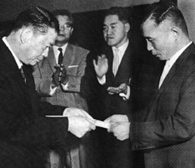 서갑호 사장(왼쪽)이 1962년 8월15일 박정희 전 대통령에게 주일대사관 기증증서를 전달하는 장면. [재일민단]