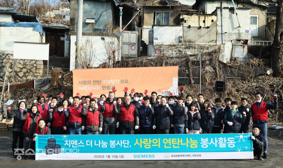 한국지멘스 ‘더 나눔 봉사단’ 구성원들이 사랑의 연탄 나눔을 마친후 함께 기념촬영을 갖고 있다.