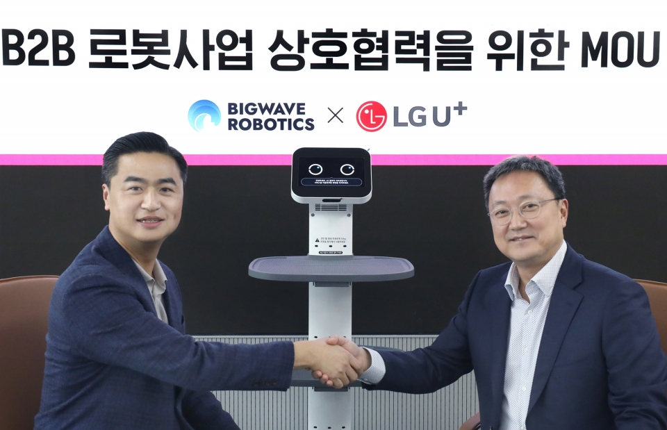 임장혁 LG유플러스 기업신사업그룹장(오른쪽)과 김민교 빅웨이브로보틱스  대표가 업무협약식에서 기념촬영을 하는 모습.