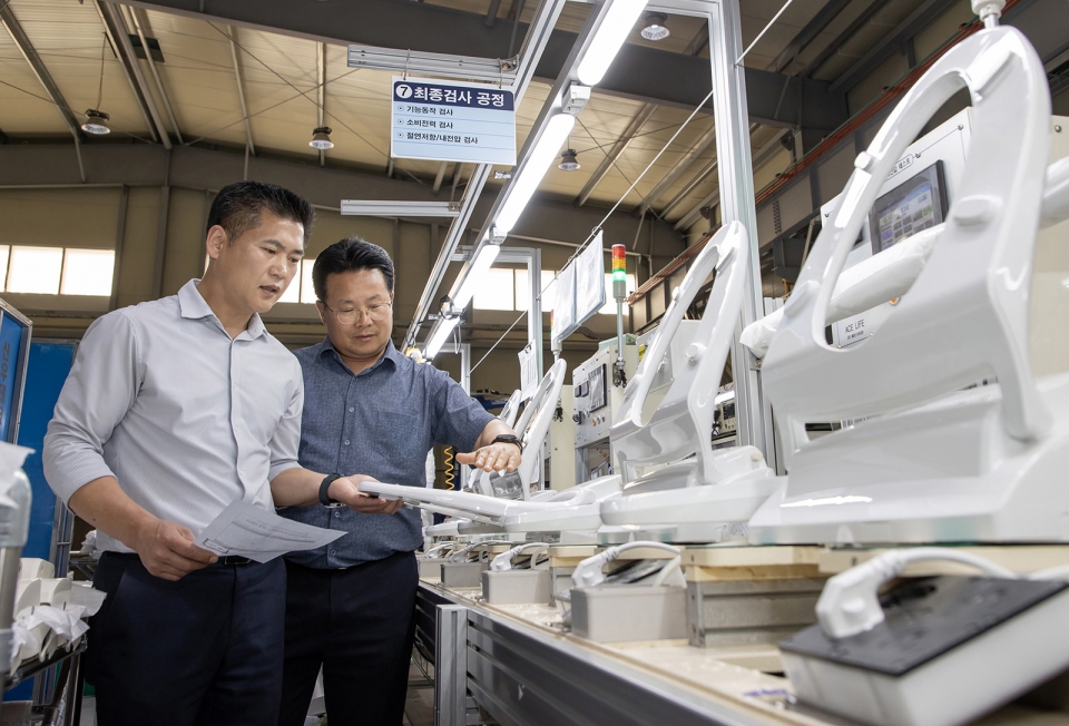 충남 아산에 위치한 비데 전문기업 '에이스라이프'에서 삼성전자 스마트공장 담당자(오른쪽)가 에이스라이프 직원과 비데 제품의 품질 상태를 점검하는 모습.