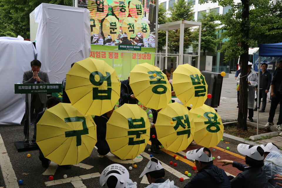 [중소기업투데이 중소기업투데이 ] 21일 국회 앞에서 열린 2024년도 최저임금 동결 촉구 결의대회에서 소상공인들이 '업종별 구분적용'을 호소하는 우산 퍼포먼스를 벌이고 있다.