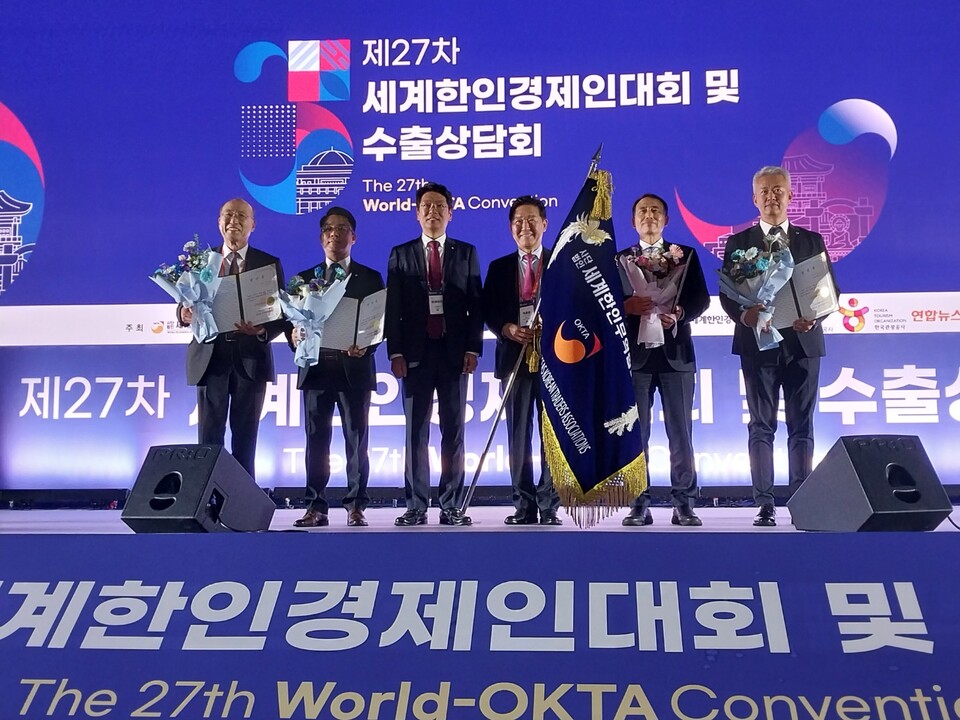 박종범 월드옥타 차기 회장(오른쪽 세번째)이 26일 저녁 수원컨벤션센터에서 열린 세계한인경제인대회 폐회식에서 대회기를 물려받은뒤 이마태오 수석부회장 및 새로운 임원진과 기념촬영을 하고 있다. [황복희 기자]