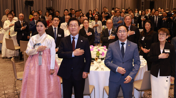 이재명 대통령과 김혜경 여사가 지난8월 24일(현지시간) 워싱턴DC 한 호텔에서 열린 재미동포 만찬 간담회에서 국민의례를 하는 모습. 이 대통령 오른쪽은 앤디 김 미국 상원의원. 이 대통령은 지난 대선과정에서 재외동포사회의 지지에 감사를 표하고 재외선거 제도 개선, 복수국적 문제 등  재외동포 권익 향상에 노력하겠다고 약속했다. [연합뉴스] 